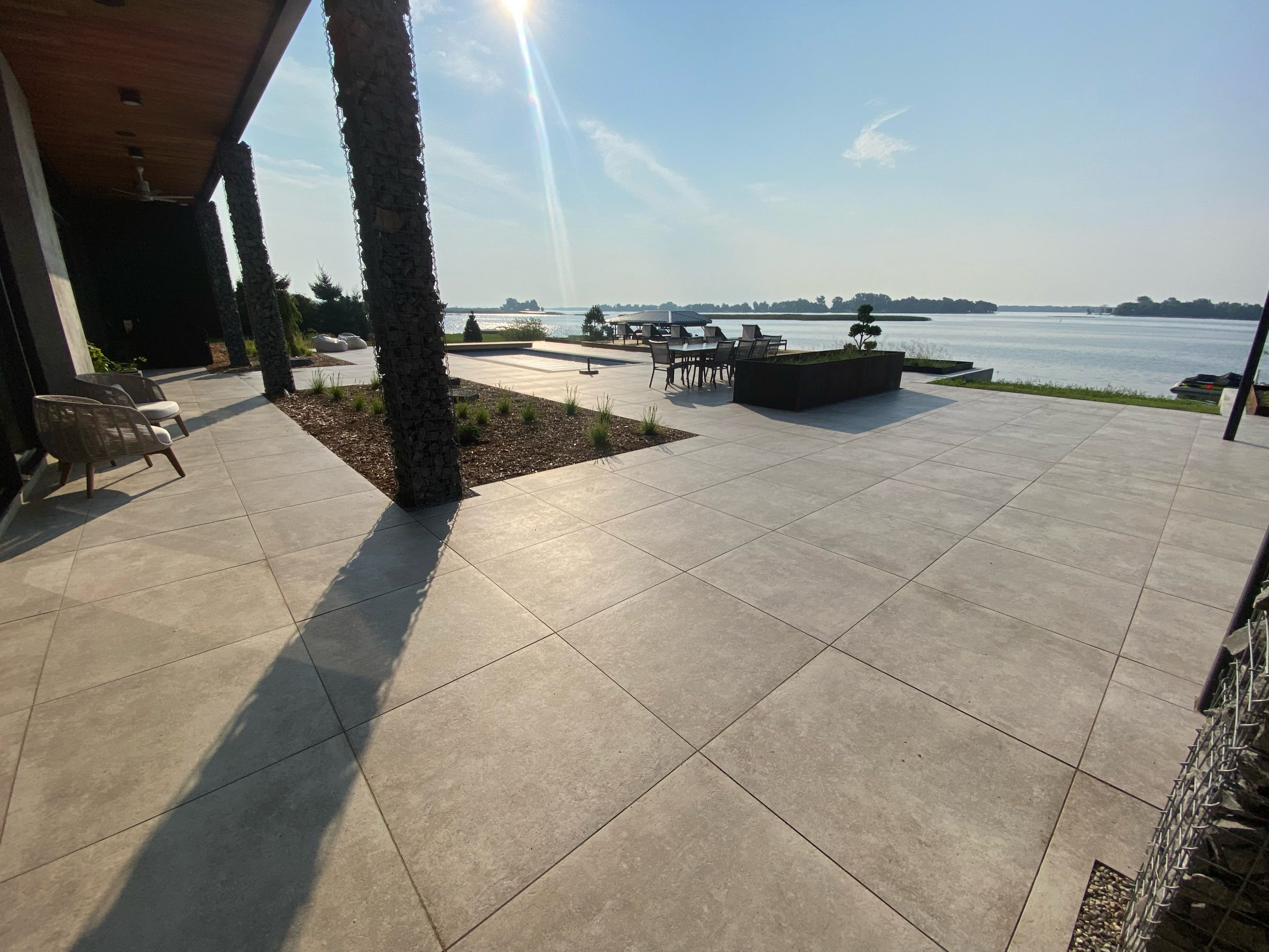 Lakeside patio with modern design and seating.