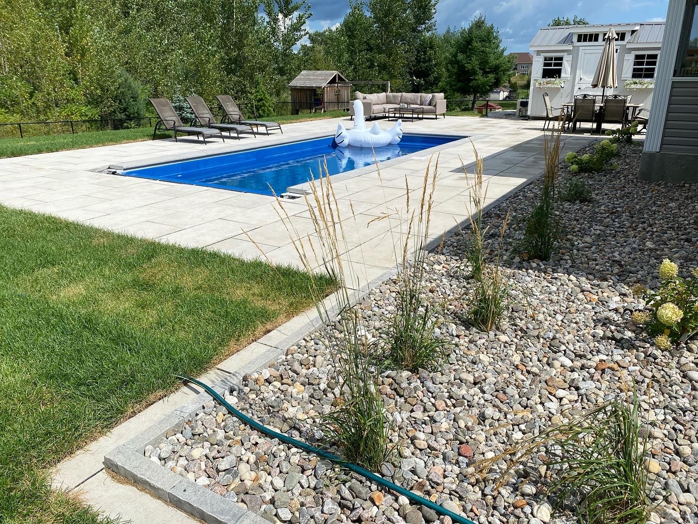 Backyard pool with lounge chairs and swan float.