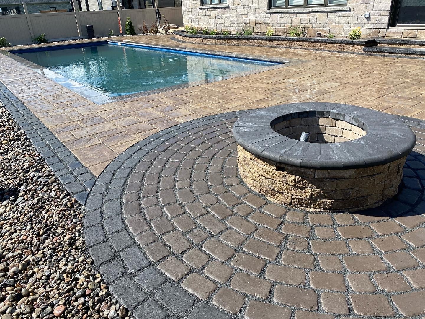 Backyard pool with stone fire pit.