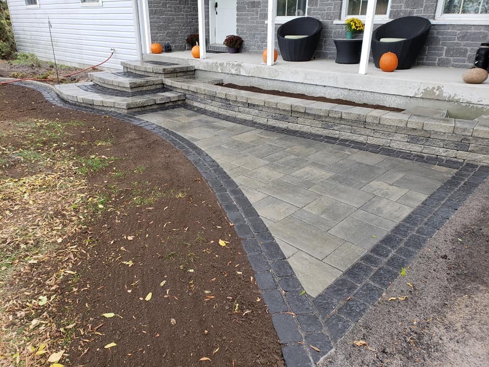 Stone patio with steps and concrete seating area.