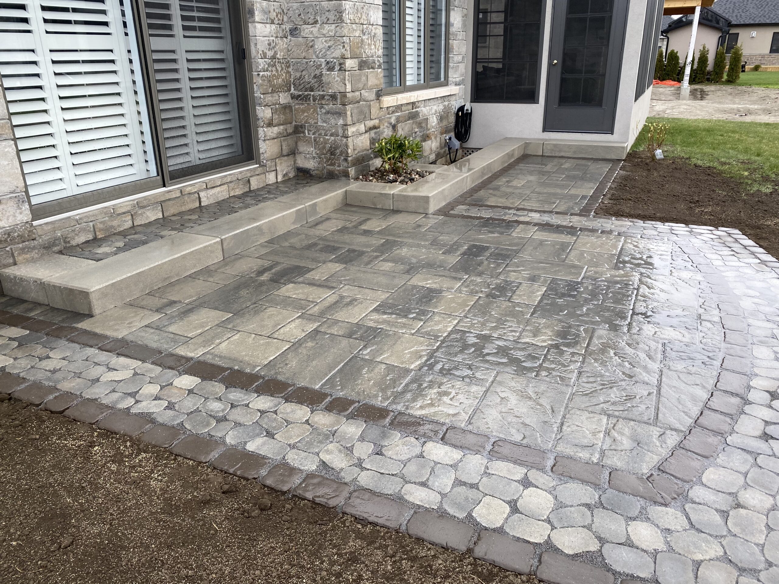 Wet stone patio outside a modern house