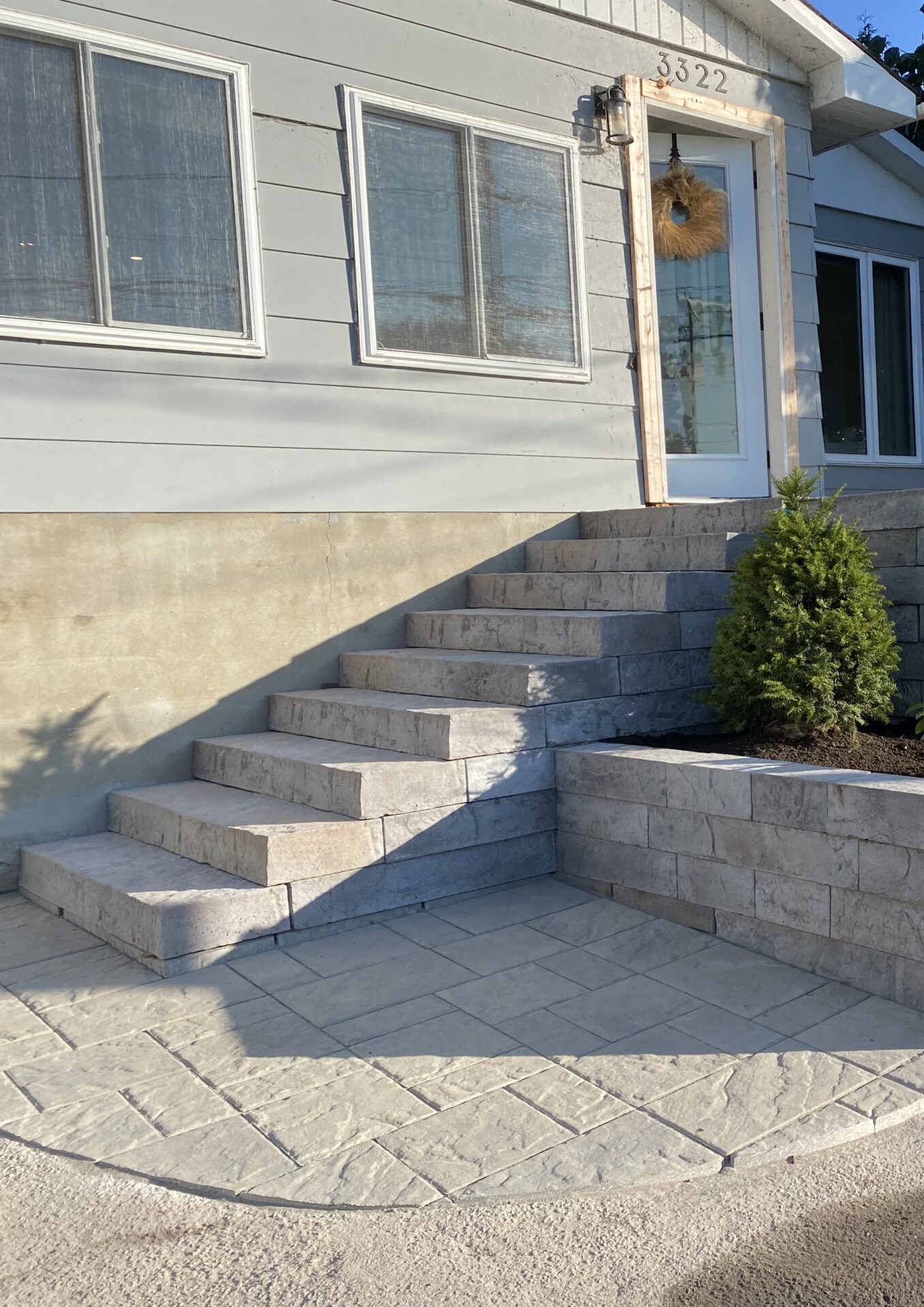 Concrete front steps with potted greenery.