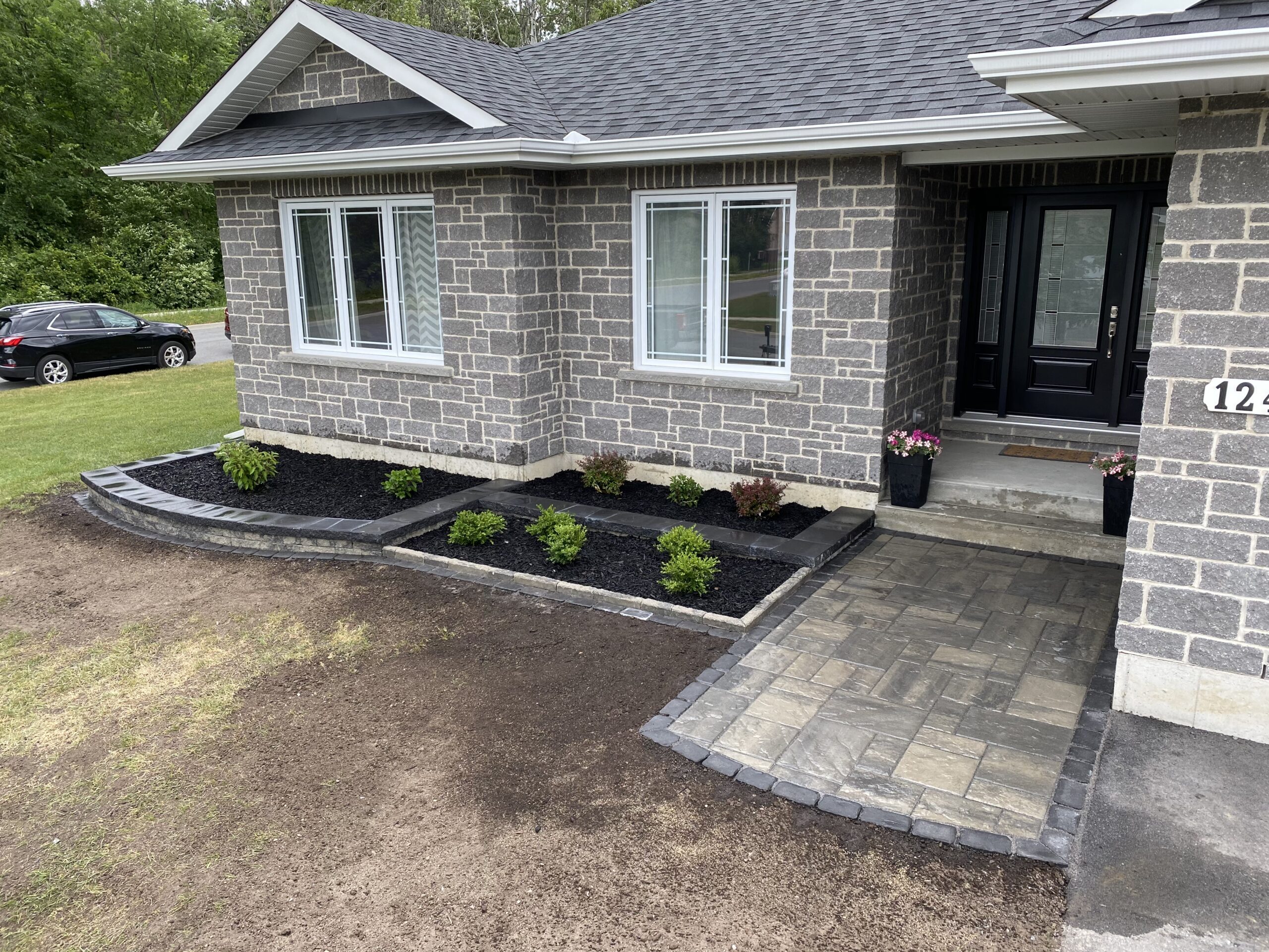 Modern brick house with landscaped front yard.
