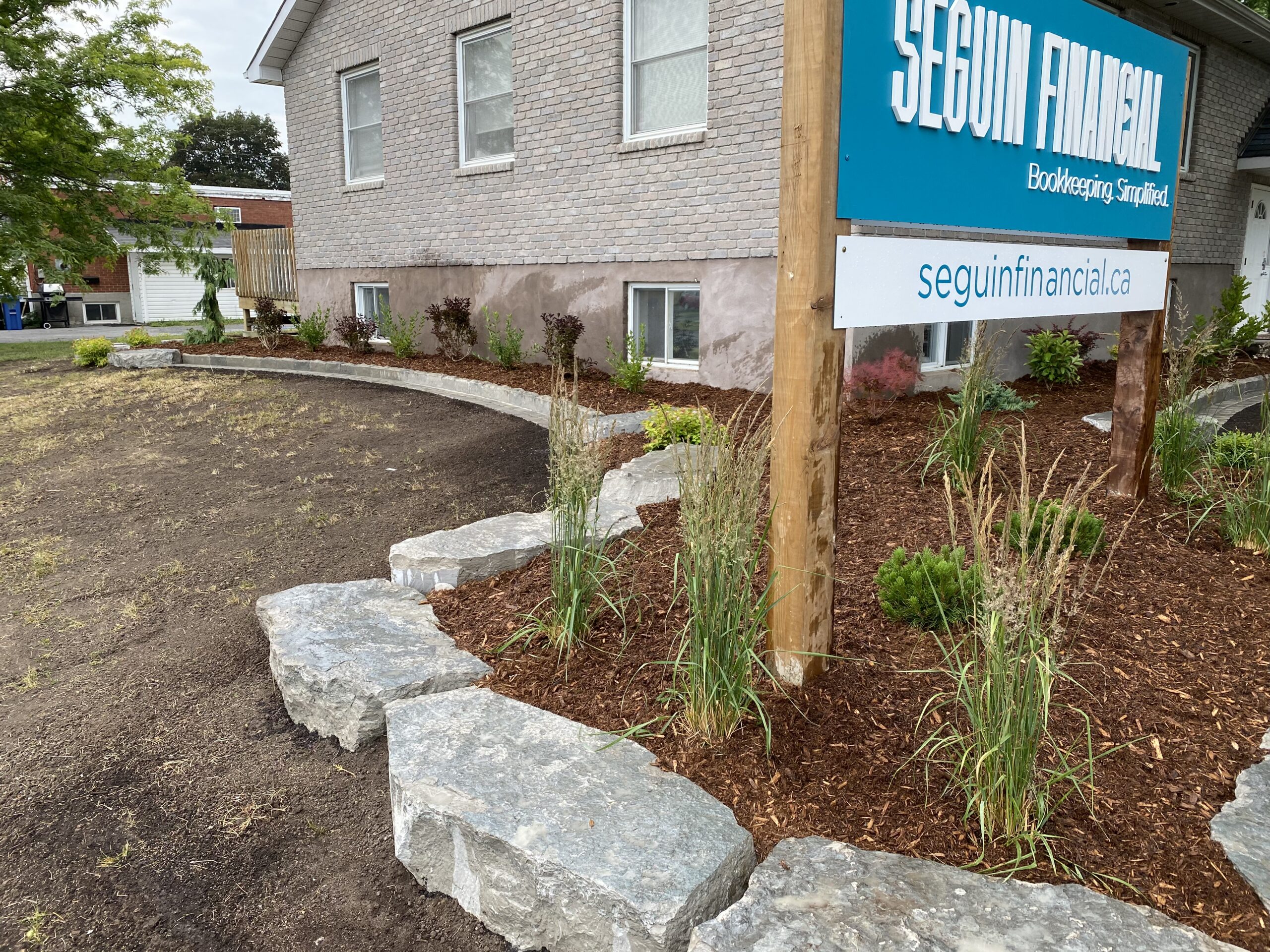 Landscaped office exterior with financial services sign.