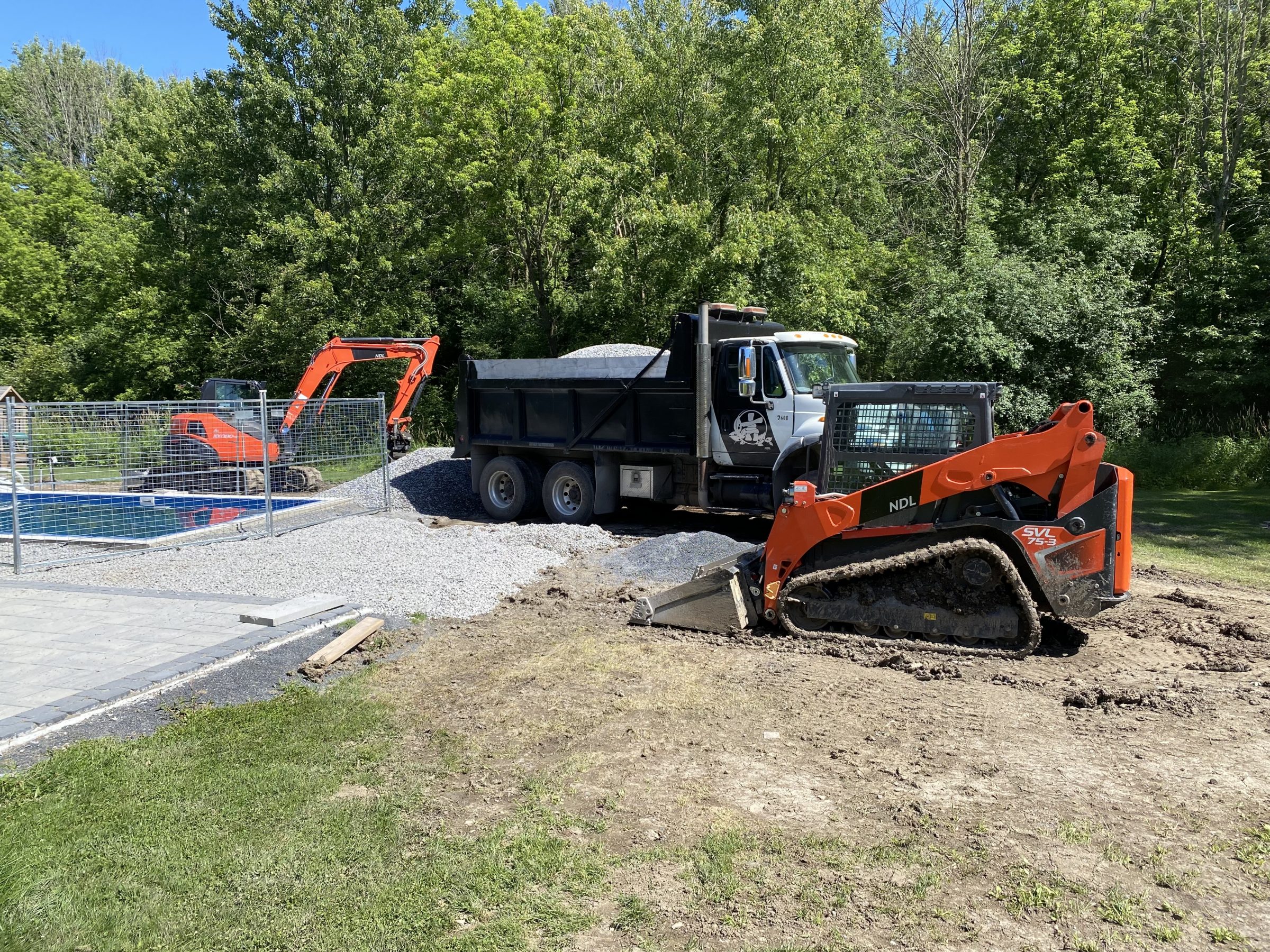 Construction site with trucks and excavator at work.