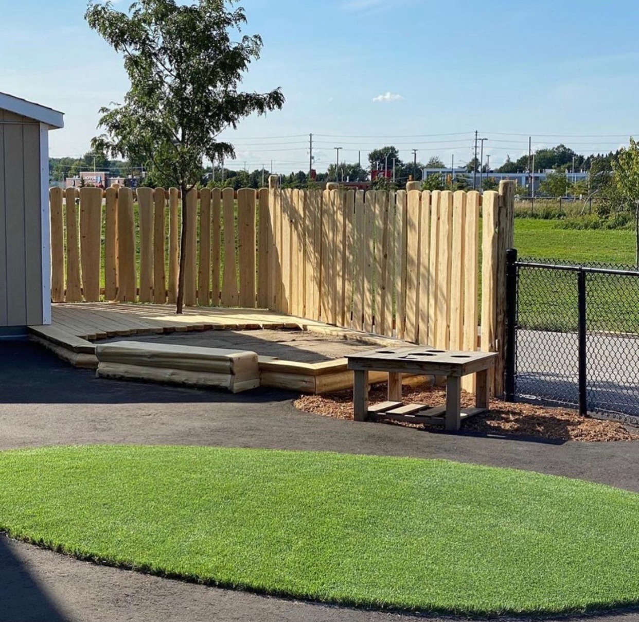Wooden fence and small artificial grass area.