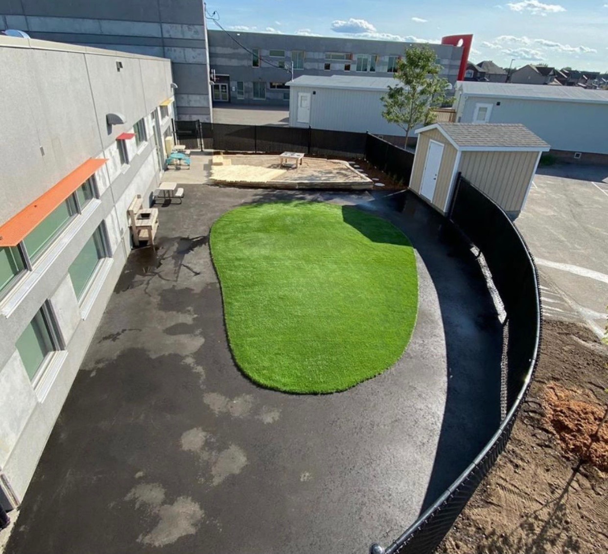 Artificial grass yard beside gray building