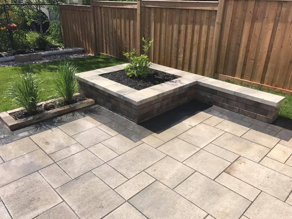 Stone patio with planter and wooden fence