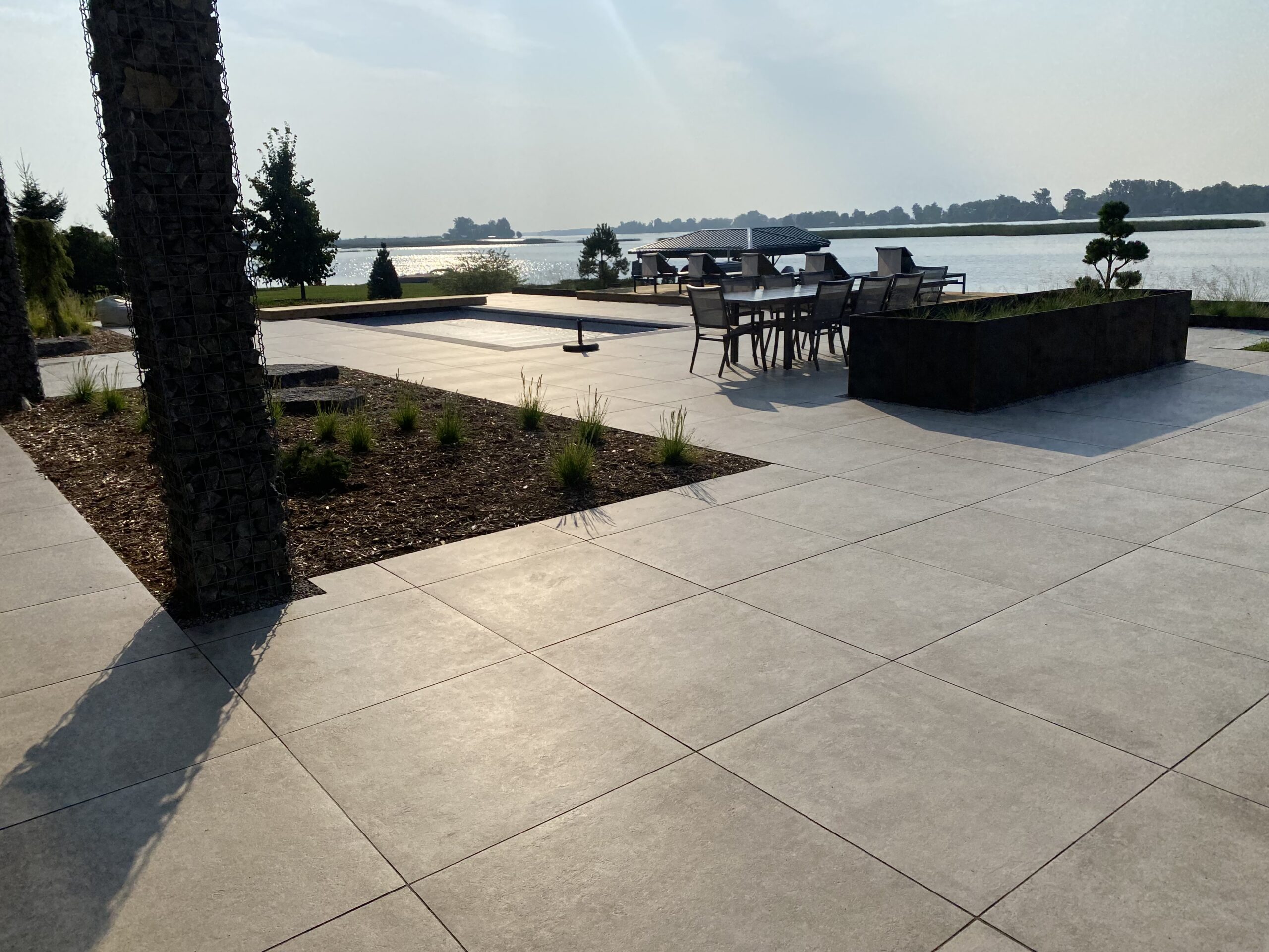 Outdoor patio with lake view and table seating.