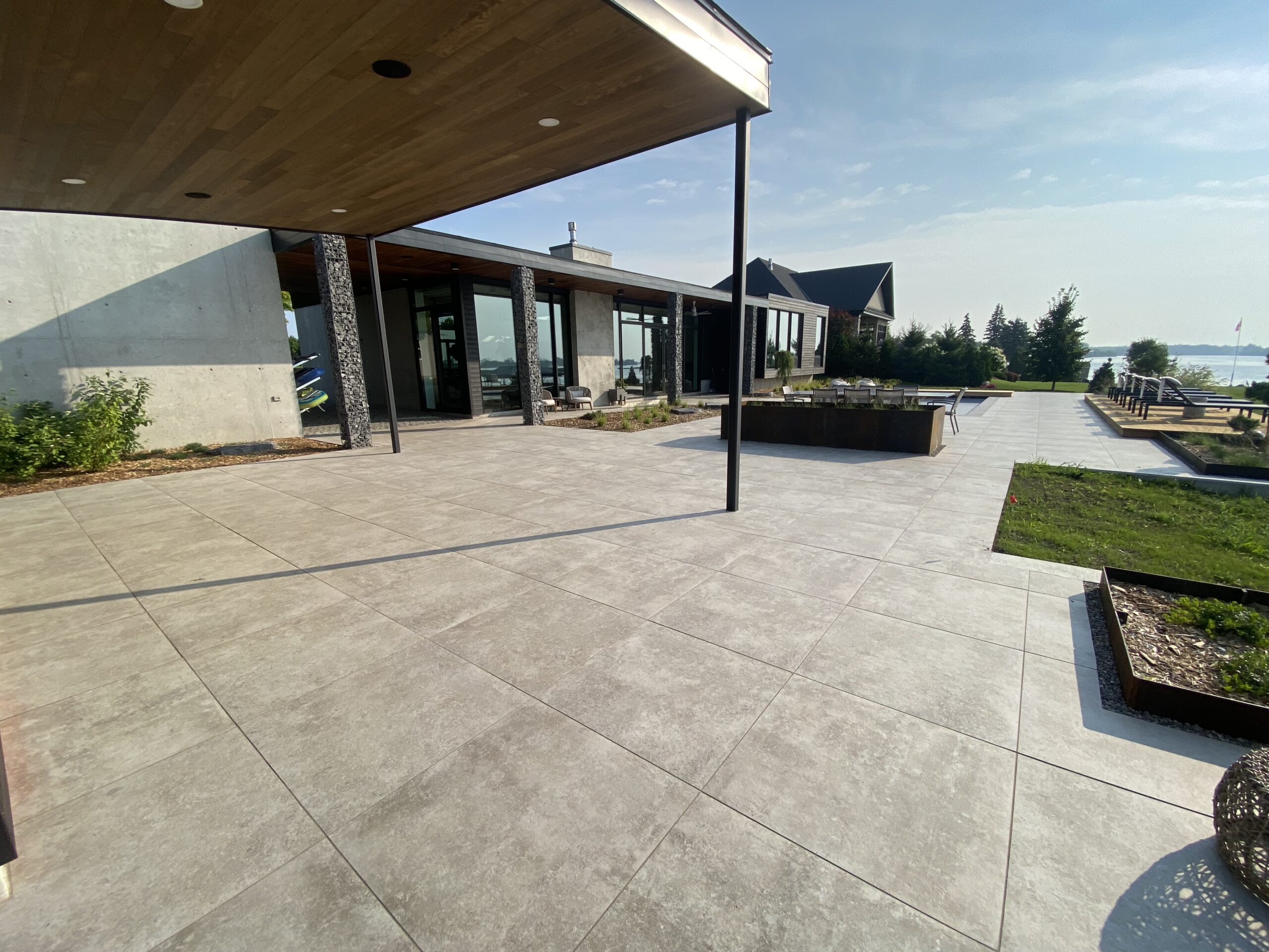 Modern patio with ocean view and greenery.