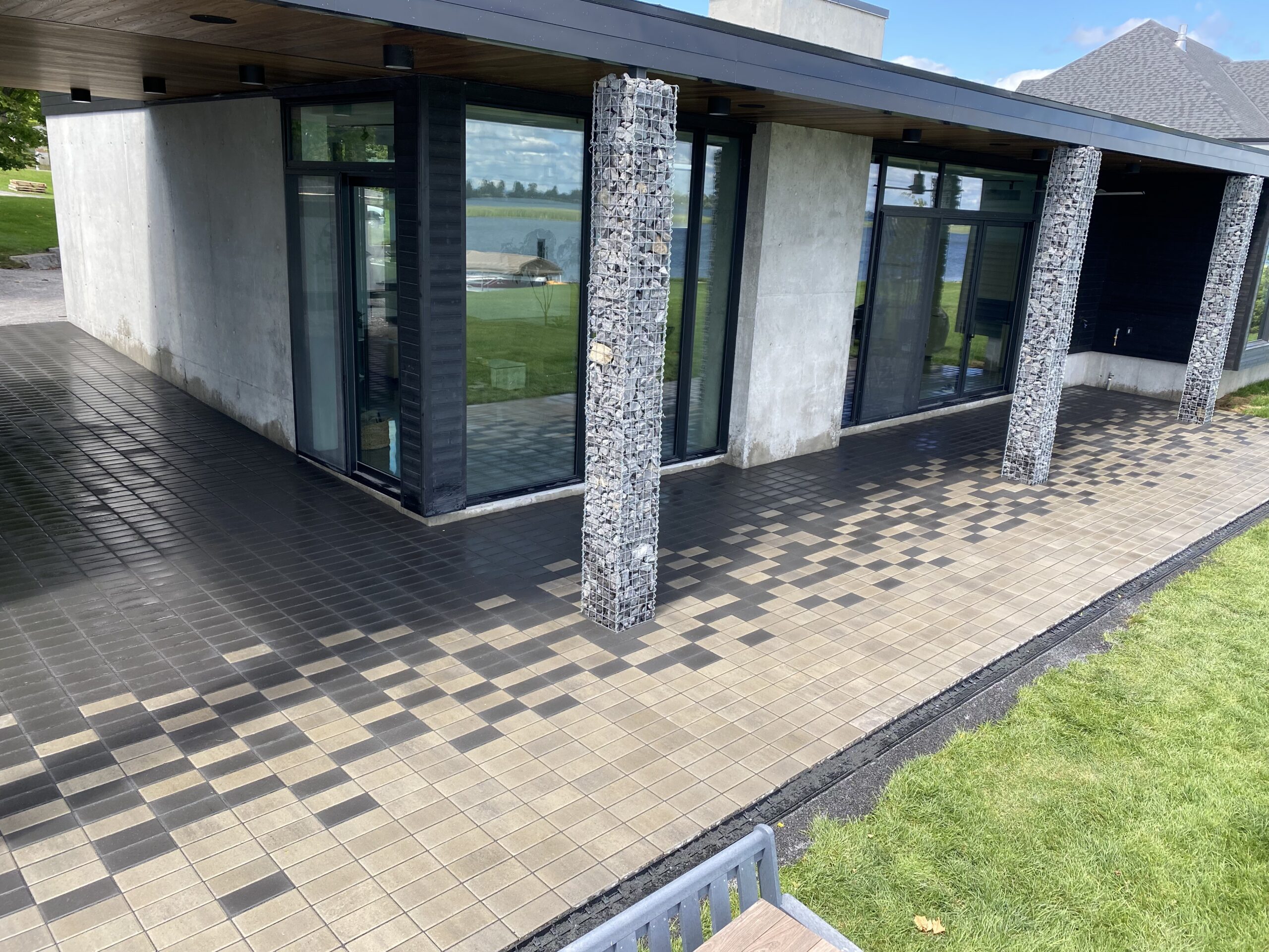 Modern patio with grid pattern tiles and glass doors.