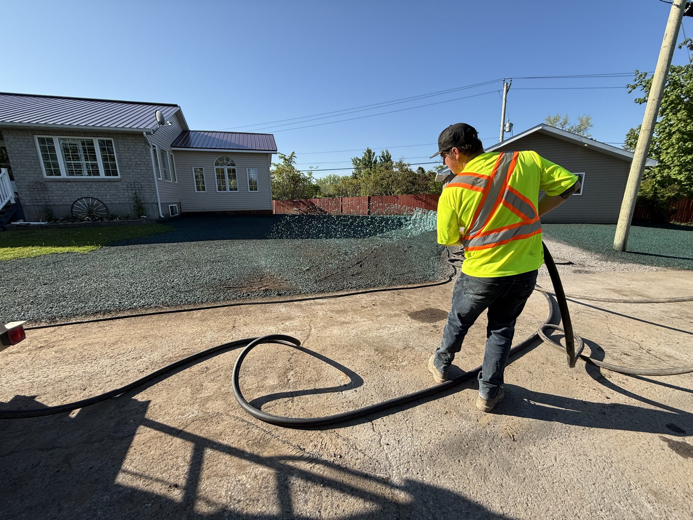 Worker spraying hydroseed on residential lawn