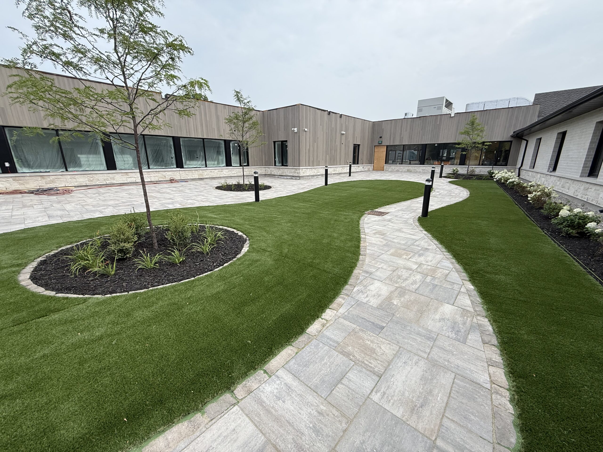 Modern courtyard with paved path and grass areas.