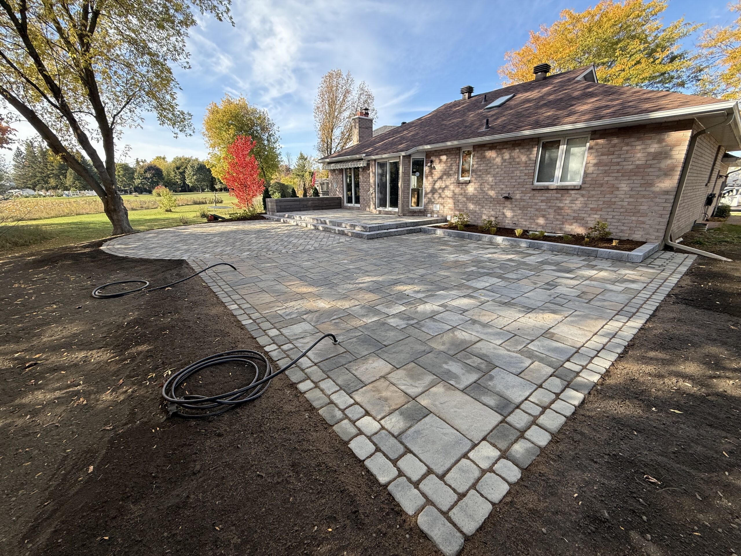 Modern patio with stone pavers and scenic backyard