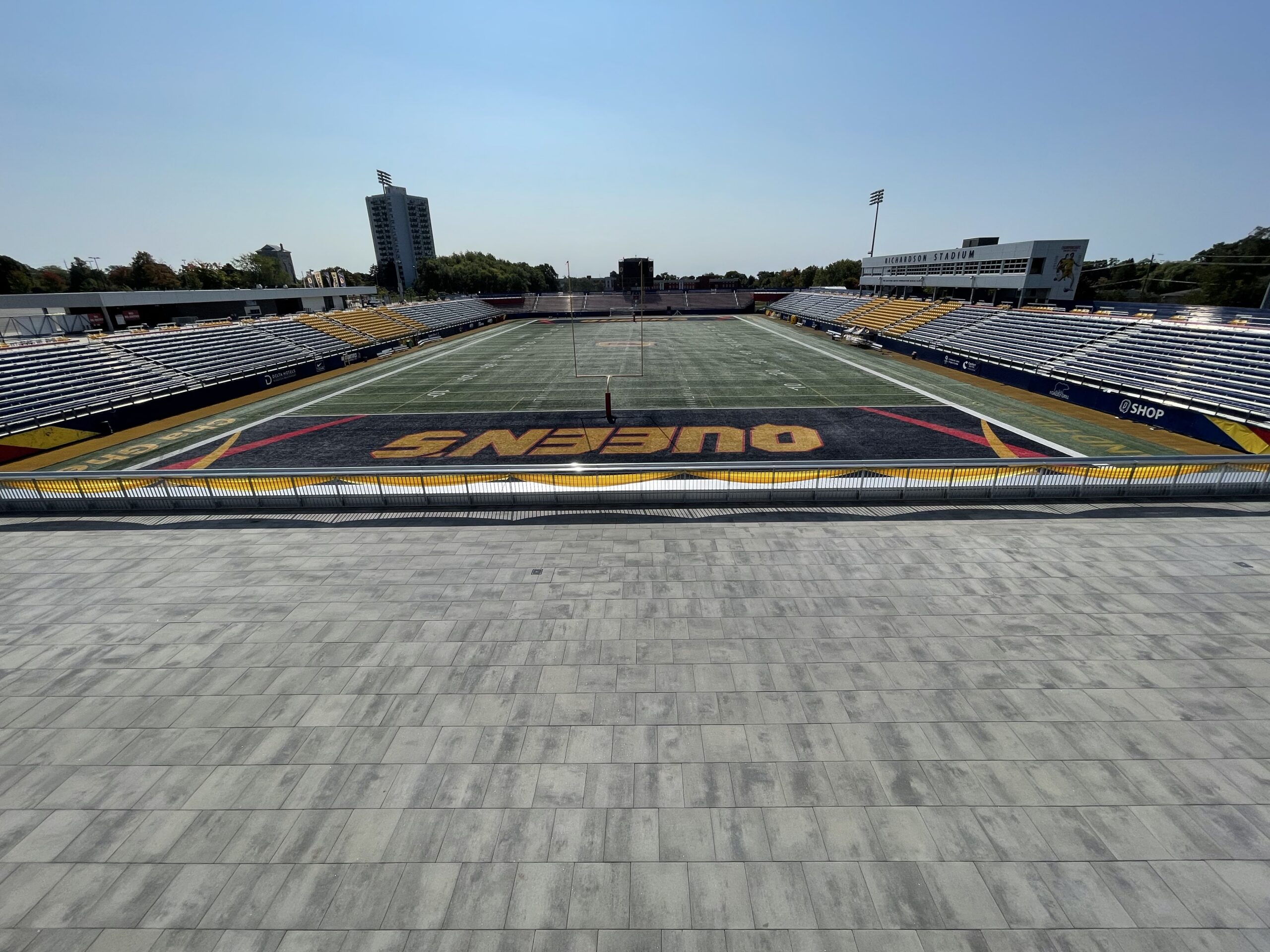 Empty outdoor football stadium with gray field.