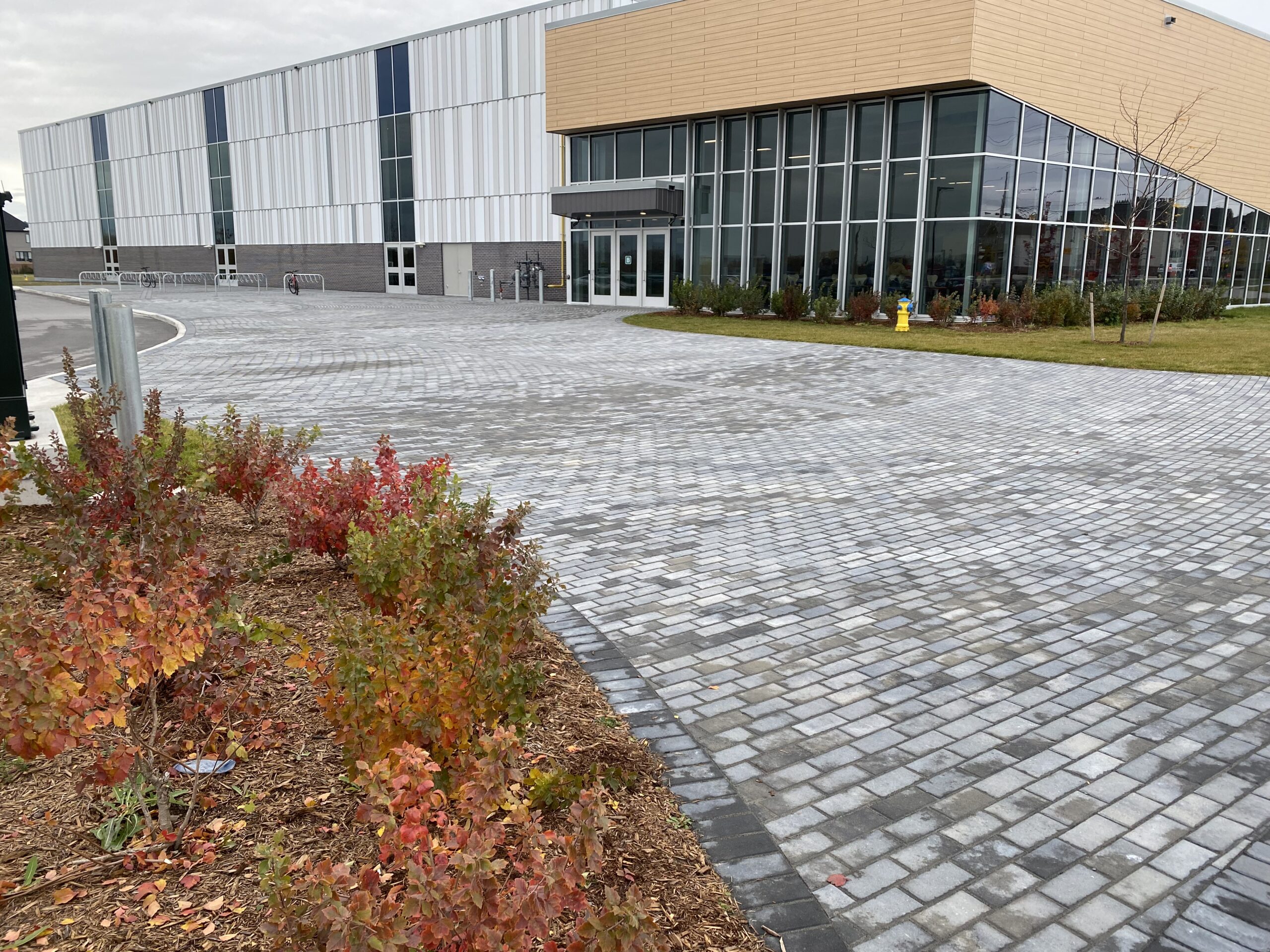Modern building with paved walkway and foliage.