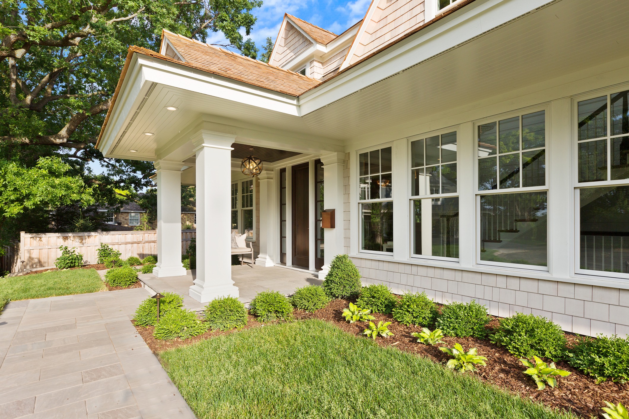 Charming house entrance with lush garden landscaping.