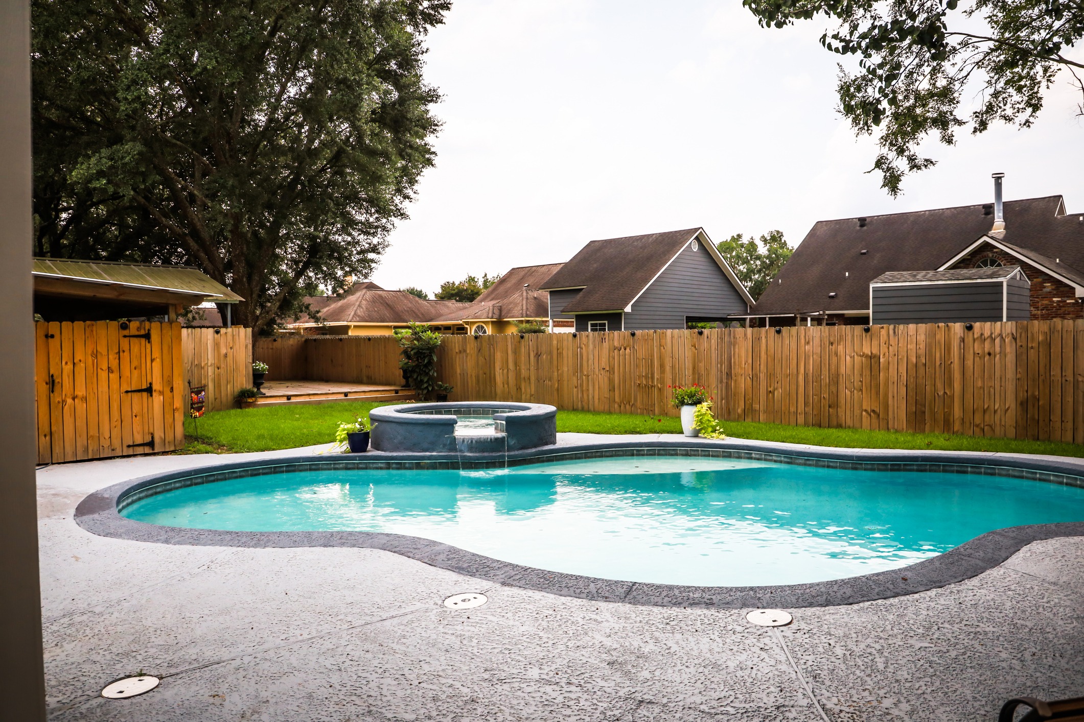 Backyard with pool and wooden fence.