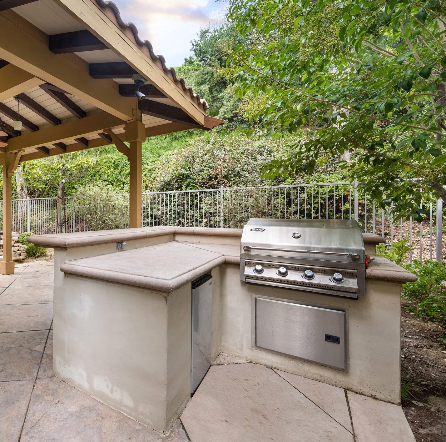 Outdoor kitchen area with built-in grill and countertop.