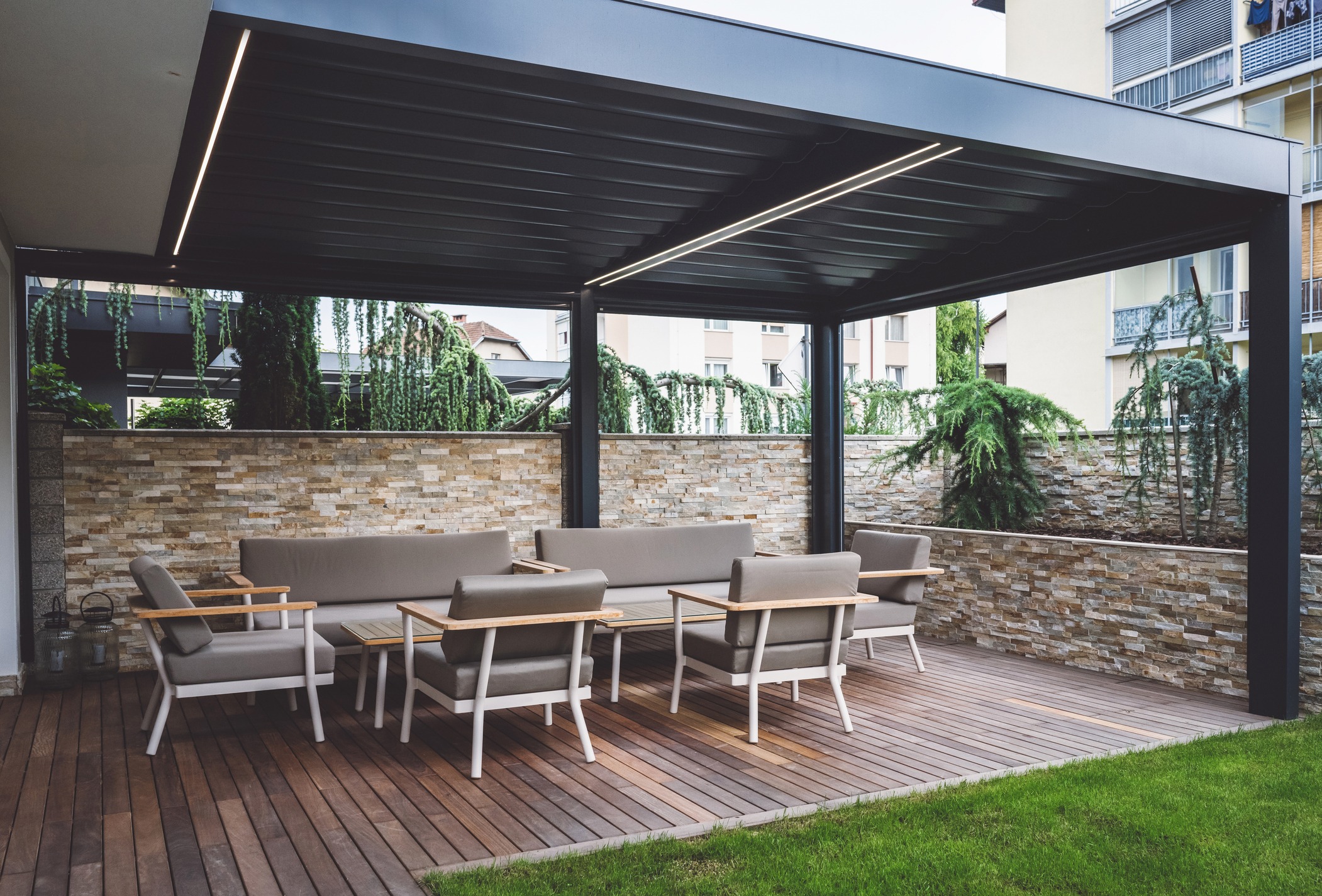 Modern outdoor patio with furniture and pergola.