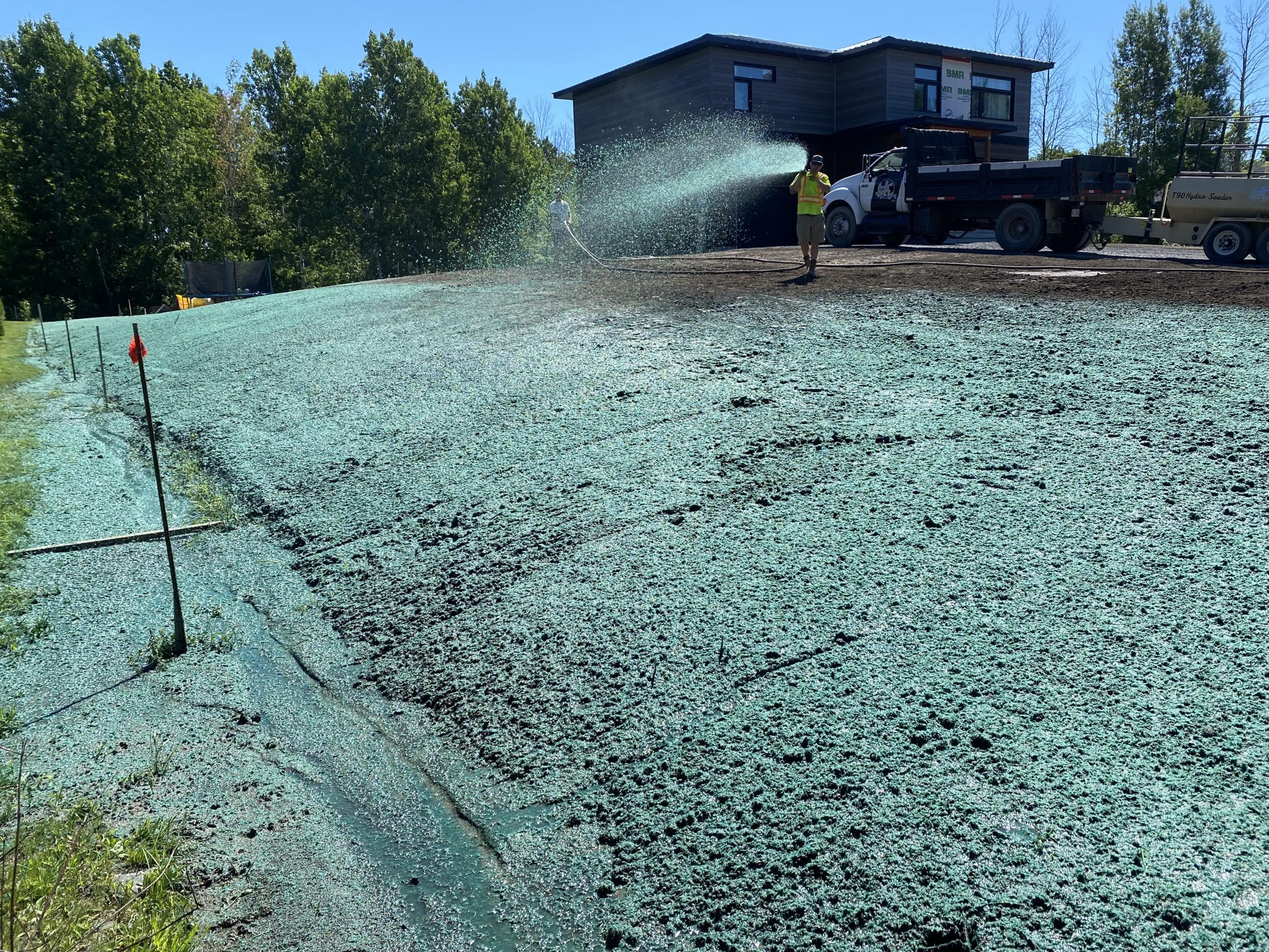 Hydroseeding a hillside for new lawn growth.